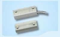 Marchio: VIMO. Articolo: CTC005SC. Contatto magnetico per installazione a vista su serramenti ferromagnetici con cavo inguainato in tubo spiralato di acciaio flessibile anti taglio. La superficie è trattata con finitura anodizzata in alluminio naturale per adattarsi a porte in ferro o blindate. Il cavo di collegamento da 150 cm a 4 conduttori consente una facile connessione. La distanza di funzionamento di 25 mm (non ferromagnetici) 12mm (ferromagnetici) garantisce funzionamento ottimale su tutte le superfici. Dimensioni mm 58x15x20 reed/magnete. Conformità EN50131-2-6 CEI 79/2 1° Liv. Cavo 5 poli 150 cm + guaina in acciaio. Contatto di scambio NA/NC V=60Vcc I=250mA VAmax=3VA.